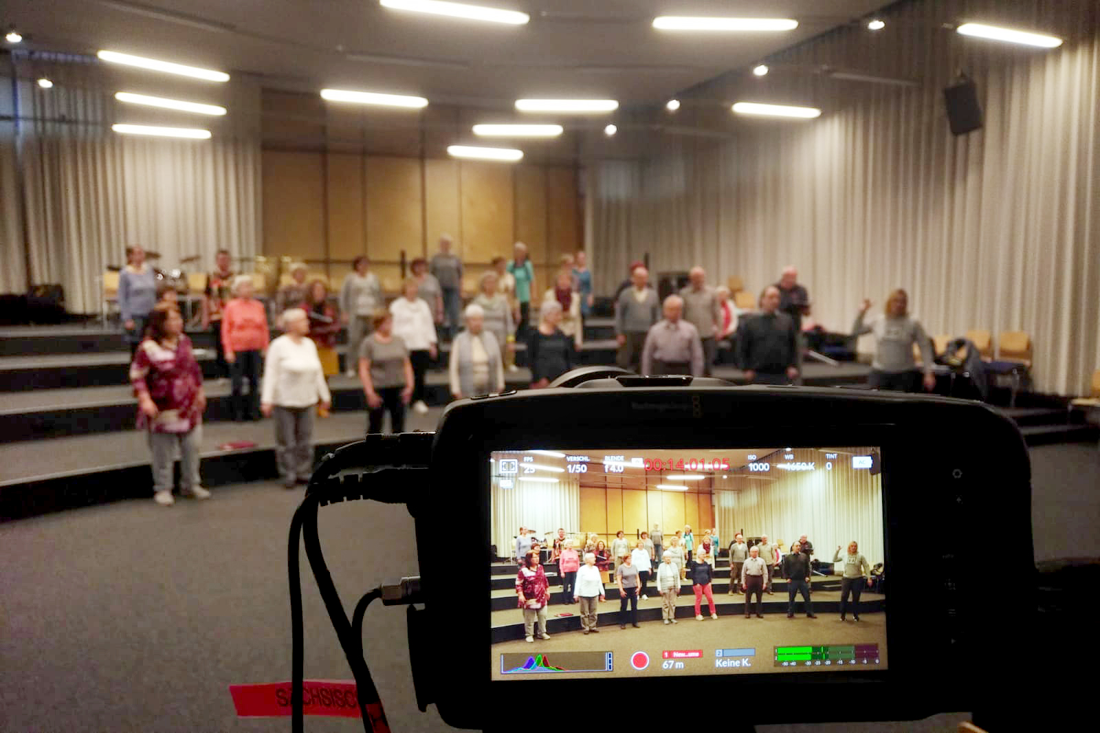 Ein Chor wird im Display einer Videokamera angezeigt.